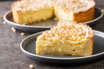 Torta della Nonna a soft flat italian cake flavoured with pine nuts closeup in the plate on the table. Horizontal