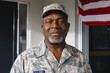 © WavebreakMediaMicro - Portrait of serious african american senior man soldier in camouflage clothing and cap against house