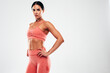 © halayalex - Tanned fitness woman in pink sports clothing. Sexy young beautiful model with perfect body.Female isolated on grey background in studio. Stretching out before training. Workout