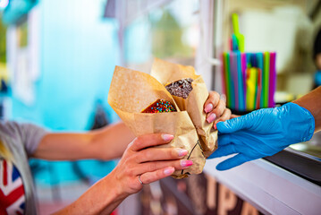 hand of chef baker holding Trdlo or Trdelnik, Traditional tasty baked Czech Republic. street food