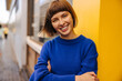 © Look! - Happy young caucasian woman smiles with her teeth at camera, relaxing outdoors. Brown-haired with bob haircut wears blue sweatshirt. Positive emotions concept