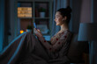 canvas print picture - technology, bedtime and people concept - happy smiling teenage girl with smartphone and earphones sitting in bed at home at night