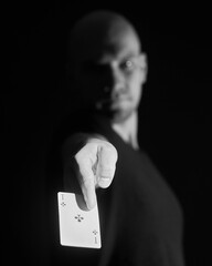 a man on a black background with an ace in his hand with two light sources