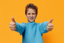 Funny, Emotional, Cute Boy Stands On A Yellow Background With A Very Happy Face And Shows Thumbs Up