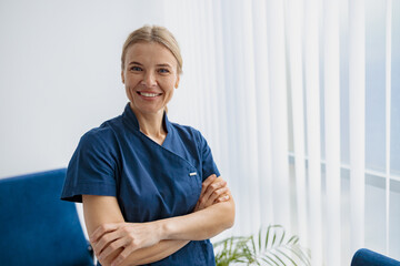 Sticker - Portrait of female doctor in uniform standing in medicine clinic hall and looking camera