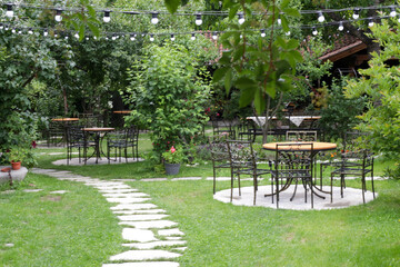 Table sets in outdoor café in beautiful green garden