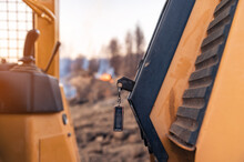 Close-up Of Keys And Control Knobs In Open Cab Of Heavy Equipment. Blurred Background Fire In The Forest.