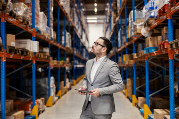 Wall Mural - An inspector with tablet checking on goods at storage.