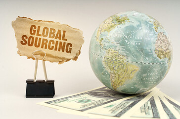 Aufkleber - On a gray surface, a globe, dollars and a cardboard plate with the inscription - GLOBAL SOURCING