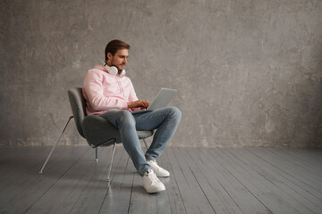 Handsome Young Freelancer Guy Using Laptop While Sitting In Arnchair At Home, Millennial Man Working Online On Computer