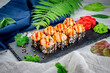Baked sushi rolls with sesame and salmon, cream cheese. Traditional Japanese cuisine