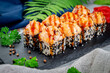 Baked sushi rolls with sesame and salmon, cream cheese. Traditional Japanese cuisine