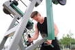 © Евгений Шемякин - portrait of handsome happy strong athletic man athlete bodybuilder training outdoors at open air gym at summer, gain hands and shoulders muscles. Bodybuilding and fitness, healthy lifestyle