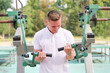 © Евгений Шемякин - portrait of handsome happy strong athletic man athlete bodybuilder training outdoors at open air gym machine at summer, gain hands and shoulders muscles. Bodybuilding and fitness, healthy lifestyle