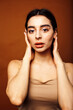 © iordani - Cute happy young indian woman on brown background in studio close up smiling, fashion beauty warm tanned