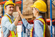 © JU.STOCKER - Colleague workers in warehouse factory have a greeting by high five with hands raised up at factory warehouse, Worker team working in warehouse
