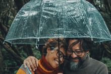 Romantic Couple In Love Under Umbrella In Rainy Day. Man And Woman Enjoy Relationship And Happiness Together In Winter Autumn Rain. Romance And People Smiling End Hugging At The Park In Leisure Moment