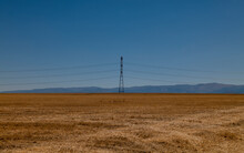 Transmission Tower On Wheat Field Against Blue Sky. Castilla Y Leon, Spain