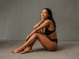 Lovely smiling African American female sitting and showing her well toned body