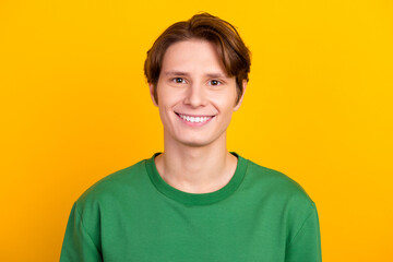 handsome caucasian man smiling with white teeth, looking confident at camera standing in green shirt