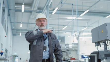 Poster - Portrait of a Middle Aged, Successful Male Engineer Putting On a White Hard Hat and Safety Glasses, While Walking at Electronics Manufacturing Factory. Heavy Industry Specialist Posing for Camera.