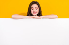 Photo Of Satisfied Funky Girl Hide Behind Empty Space Blank Look Down Isolated On Yellow Color Background