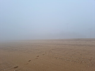 a landscape of a misty beach sandy beach