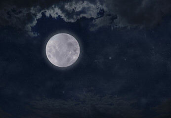 high full moon night time cloudscape - dark blue night sky with a bright full moon off centre and cl