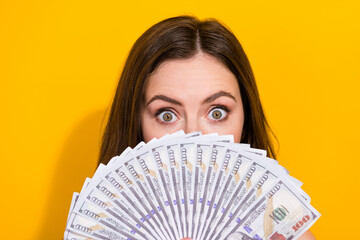 Sticker - Portrait of shocked impressed girl hide face behind usd banknotes look camera isolated on yellow color background