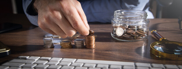 Canvas Print - Male hand stacking coins. Saving money