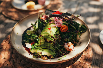 Fresh healthy avocado and shrimps salad served outdoors