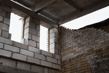 Construction Site. Under Construction Garage Made Of Bricks And Concrete Blocks, View Inside. Window Openings, Ceiling And Walls