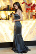 © Dragosh - Full length image of a brunette woman dressed slim grey dress and makeup, posing at the bar with glass.