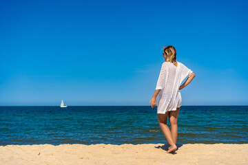 Woman walking on sunny beach