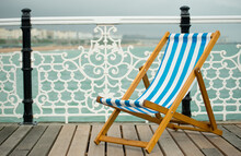 Seaside Deck Chair On Brighton Pier Promenade Without People.