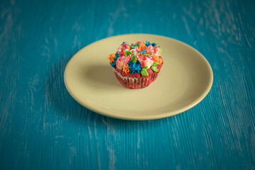 Wall Mural - Delicious organic homemade cupcake on a colorful ceramic plate.