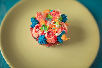 Wall Mural - Delicious organic homemade cupcake on a colorful ceramic plate.