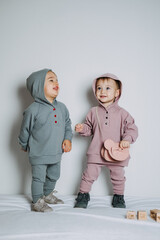 Wall Mural - Baby fashion. Unisex clothes for babies. Two Cute baby girls or boys in cotton set