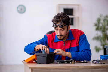 Young male repairman repairing computer