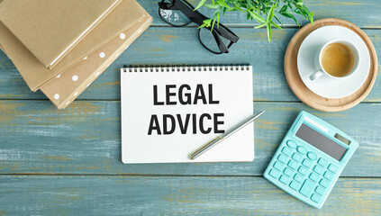 Wall Mural - Concept Legal Advice message on notebook with glasses, pencil and coffee cup on wooden table