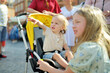 © MNStudio - Cute toddler boy and his older sister explore beautiful streets of Warsaw's Old Town. Teenage girl and her brother in a stroller outdoors.