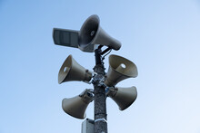 Ve Gray Loudspeakers Attached To A Tall Pillarack, Rack, Hazard Warning System. Providing Security In The City, Notification Of Emergencies.