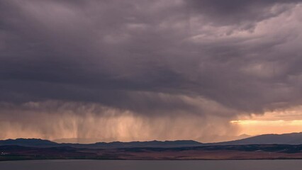 Wall Mural - Time lapse of storm moving over the landscape at sunset on the edge of Utah Lake.