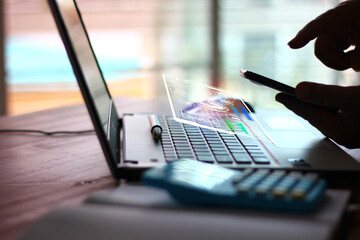 Wall Mural - man using mobile phone with futuristic digital technology icon accessibility while working with laptop , technology concept