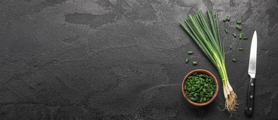 Composition with green onion on black background with space for text