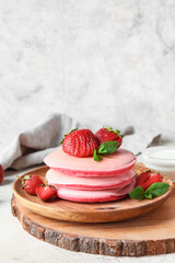 Wall Mural - Wooden board with plate of tasty pancakes and strawberry on table, closeup