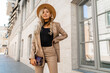 © Svetlana Sokolova - Fashion photo of gorgeous beutiful blond model posing in trendy leather  jacket and pants outdoor. Wearing beige hat.