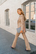 © Svetlana Sokolova - Sucsessful blond business woman posing in stylish suit outdoor. Holding  bdesigner catalogs.  Full lenght.