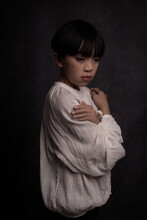 Classic Studio Portrait Of Asian Boy In White Blouse In Dark Renaissance Style