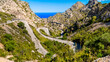 View to the mediterranean sea down the narrow Serra de Tramuntana pass road MA-2141 winding in serpentines down to tourist attraction Sa Calobra at Mallorca below the famous place Nus de sa Corbata.